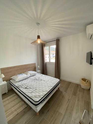 une chambre avec un lit dans une pièce avec une fenêtre dans l'établissement Ajaccio magnifique T2 37m2 centre ville vue mer au bord de la plage Neuf 4 couchages balcon parking privé fermé Clim wifi, à Ajaccio