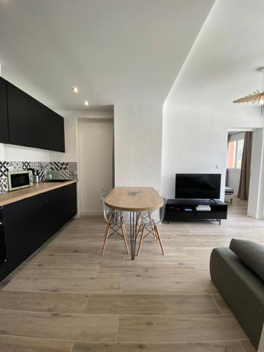 un salon avec une table et une cuisine dans l'établissement Ajaccio magnifique T2 37m2 centre ville vue mer au bord de la plage Neuf 4 couchages balcon parking privé fermé Clim wifi, à Ajaccio