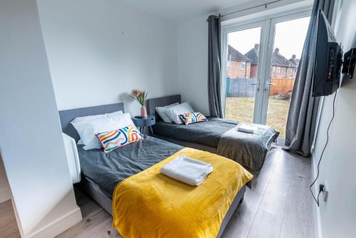 two beds in a room with a window at Flat 03 Studio flat near Aylesbury Station Free Parking in Buckinghamshire