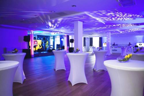 a room with white tables and white stools at Mercure Wiazowna Brant in Wiązowna