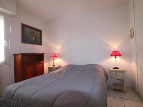 - une chambre avec un lit et 2 tables avec des lampes dans l'établissement Appartement 40m² avec terrasse et 2 chambres à 4, face à la plage du Lazaret - FR-1-472A-157, à Sète