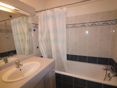 une salle de bain avec un lavabo et une baignoire et un lavabo dans l'établissement Appartement 40m² avec terrasse et 2 chambres à 4, face à la plage du Lazaret - FR-1-472A-157, à Sète