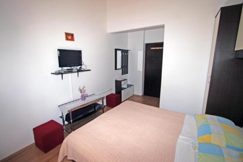 ein Schlafzimmer mit einem Bett und einem TV an der Wand in der Unterkunft Apartments & Rooms Lo & Mar in Medulin