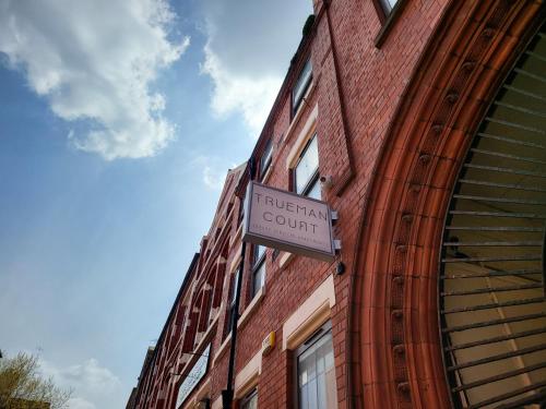 a sign on the side of a brick building at Trueman Court Luxury Serviced Apartments in Liverpool