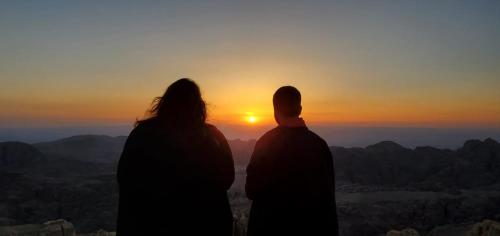 a man and a woman standing in front of a sunset at Petra Desert Dream Hotel in Wadi Musa