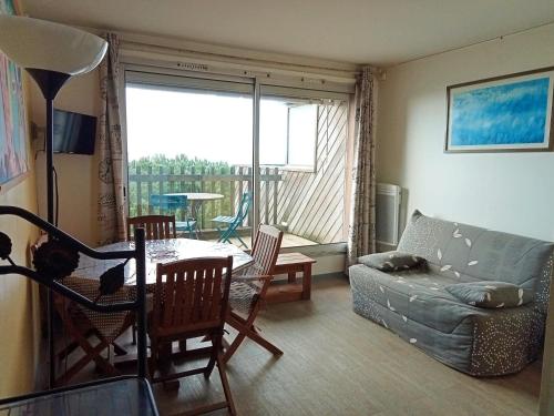 un salon avec un canapé et une table dans l'établissement La Rochelle: Bel app. 4 pers avec balcon vue mer, parking, proche plage - FR-1-551-50, à La Rochelle