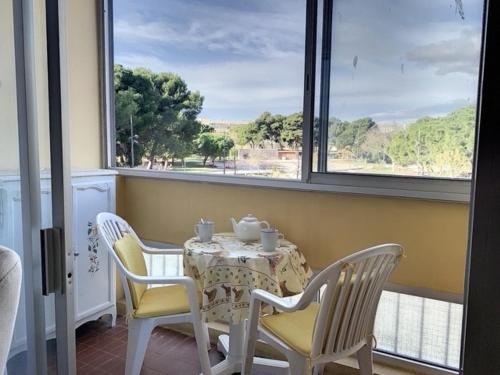 une salle à manger avec une table, des chaises et des fenêtres dans l'établissement Appartement cosy proche des Thermes avec balcon, WiFi et parking - FR-1-503-117, à Balaruc-les-Bains