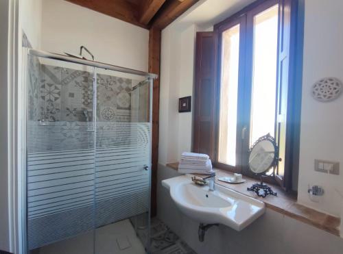 een badkamer met een glazen douche en een wastafel bij Palazzo Laureano - Dimora Storica in Tricarico