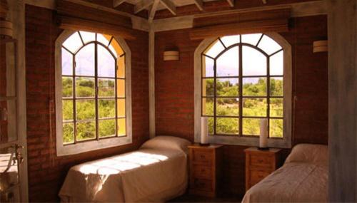 a bedroom with two windows and two beds in it at Las Nubes Apart in Merlo