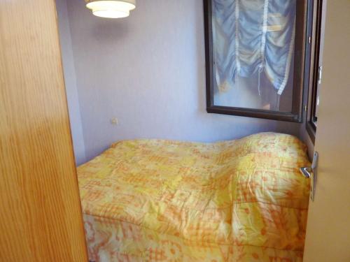 ein kleines Schlafzimmer mit einem Bett und einem Spiegel in der Unterkunft Appartement Marseillan-Plage, 2 pièces, 6 personnes - FR-1-387-165 in Marseillan