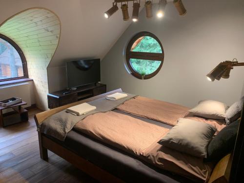 a bedroom with a large bed and a window at SASKI ZAKĄTEK, WAKACJE W BAJKOWYM DOMKU!!! MAZURY, SAUNA, JEZiORO, POMOST, in Sasek Mały