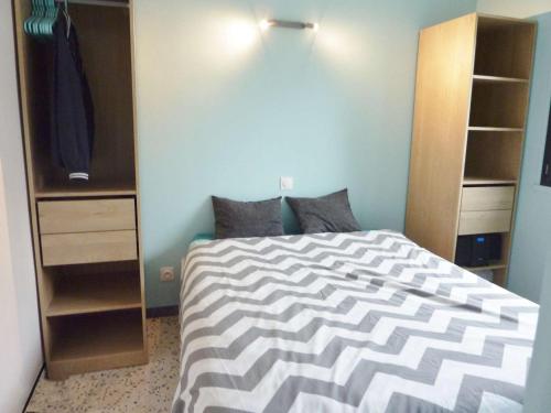 - une chambre avec un lit et un placard dans l'établissement Appartement T2 rénové, climatisé, avec terrasse et parking, proche plage - FR-1-387-166, à Marseillan