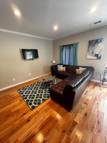 a living room with a leather couch and a television at Atlanta Unit 2 Room 1 - Quiet Private Bedroom Private Bathroom in Atlanta