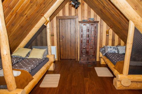 two beds in the attic of a cabin at SASKI ZAKĄTEK, WAKACJE W BAJKOWYM DOMKU!!! MAZURY, SAUNA, JEZiORO, POMOST, in Sasek Mały