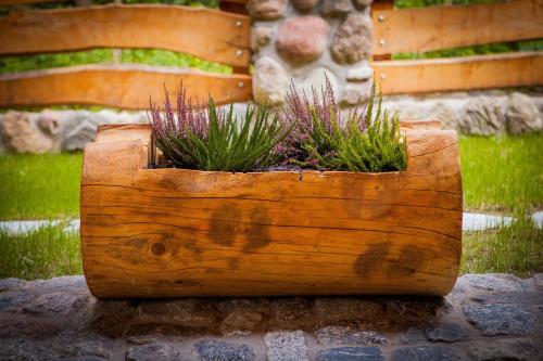 a wooden planter with purple plants in it at SASKI ZAKĄTEK, WAKACJE W BAJKOWYM DOMKU!!! MAZURY, SAUNA, JEZiORO, POMOST, in Sasek Mały