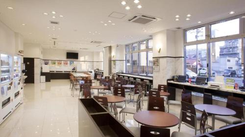 une salle à manger avec des tables et des chaises dans un restaurant dans l'établissement Toyoko Inn Yokohama-sen Fuchinobe-eki Minami-guchi, à Sagamihara