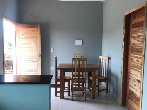 a dining room with a wooden table and chairs at Cristiane e José Neto in Salinópolis