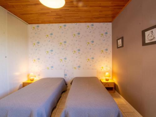 dwa łóżka w pokoju z dwoma lampami na ścianie w obiekcie Gîte Domme, 4 pièces, 6 personnes - FR-1-616-3 w mieście Domme