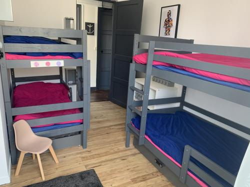 Cette chambre comprend 2 lits superposés et une chaise. dans l'établissement Maison rénovée 10 pers à Fort-Mahon-Plage, à 150m de la plage - FR-1-482-84, à Fort-Mahon-Plage
