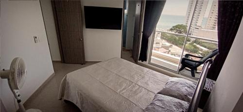 a bedroom with a bed and a large window at Rodadero - Hermoso Apartamento con vista al Mar, Piscina y Playa Aragoa - Santa Marta in Gaira