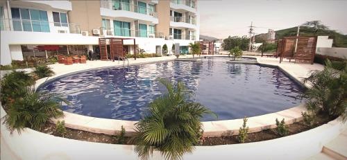 a large swimming pool in front of a building at Rodadero - Hermoso Apartamento con vista al Mar, Piscina y Playa Aragoa - Santa Marta in Gaira