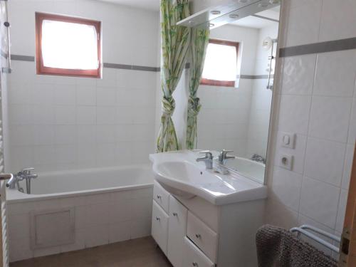 une salle de bain blanche avec un lavabo et une baignoire dans l'établissement Appartement spacieux 3*, 1er étage d’un chalet, centre village, proche commerces et pistes, 200m des pistes - FR-1-618-3, à Albiez-Montrond