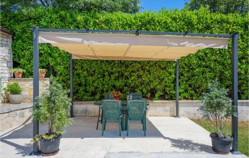 a patio with a table and chairs under a canopy at One-Bedroom Holiday Home In Zminj in Žminj