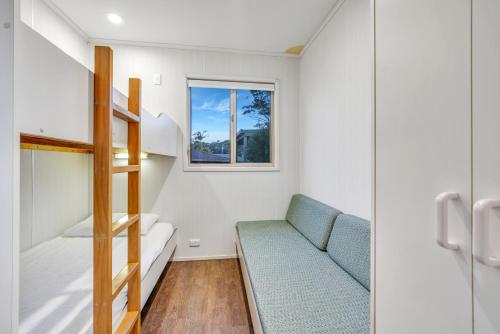 a tiny house with a staircase and a couch at Ingenia Holidays Merry Beach in Kioloa