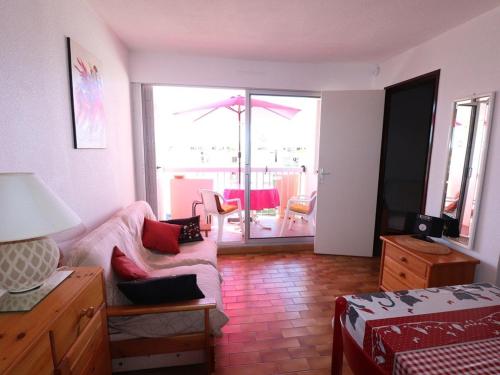 un salon avec un canapé et une chambre avec un patio dans l'établissement 2 pièces Cabine, Terrasse Sud, proche mer & commerces, Le Grau-du-Roi - FR-1-307-163, au Grau-du-Roi