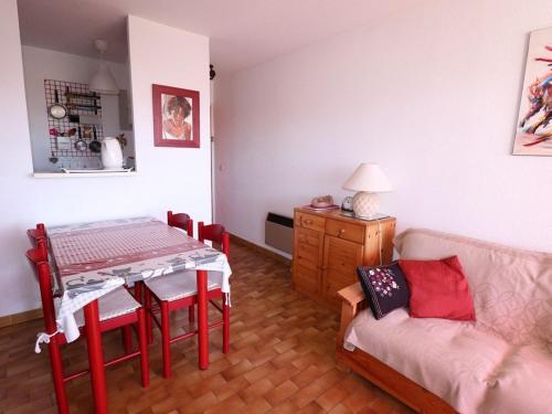 un salon avec une table et un canapé dans l'établissement 2 pièces Cabine, Terrasse Sud, proche mer & commerces, Le Grau-du-Roi - FR-1-307-163, au Grau-du-Roi
