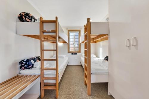 a room with bunk beds and a ladder at Ingenia Holidays Merry Beach in Kioloa