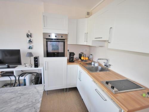 une cuisine avec des armoires blanches et un évier dans l'établissement Studio Centre-Ville Royan : Plages et Commerces à Pied, Balcon, Parking Gratuit - FR-1-550-7, à Royan