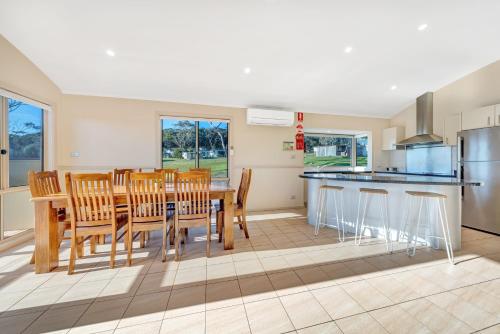 a kitchen and dining room with a table and chairs at Ingenia Holidays Merry Beach in Kioloa