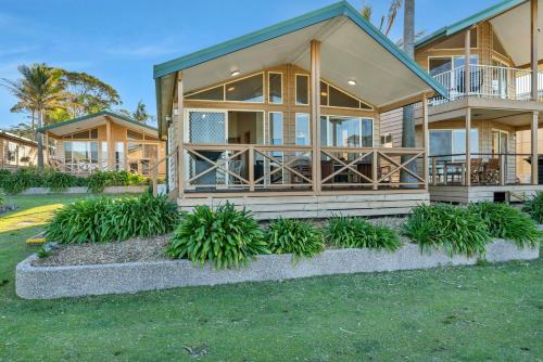 a house with large windows and plants in front of it at Ingenia Holidays Merry Beach in Kioloa