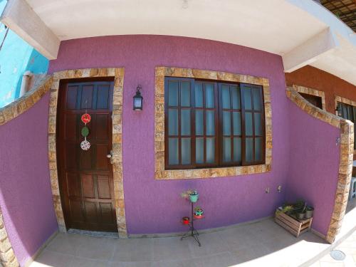 una casa con una pared púrpura y dos puertas en Vila da Drika en Rio das Ostras