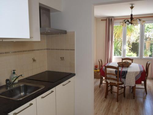 - une cuisine avec un évier et une table avec une salle à manger dans l'établissement Maison 2 étoiles proche plage & marché, avec jardin et terrasse, idéale pour familles. - FR-1-197-499, à Les Sables-dʼOlonne