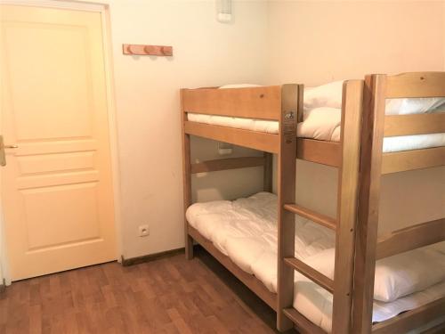 a room with two bunk beds and a door at Chalet La Joue du Loup, 3 pièces, 8 personnes - FR-1-504-616 in Le Dévoluy