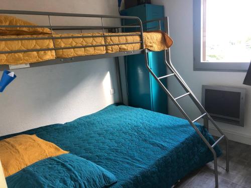 - une chambre avec des lits superposés et une couette bleue dans l'établissement Appartement 2 pièces climatisé, parking privé, proche plage - FR-1-81-535, à Port-Leucate