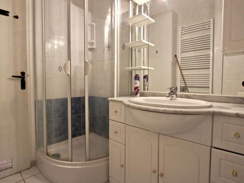 uma casa de banho branca com um chuveiro e um lavatório. em Appartement Chamrousse, 2 pièces, 4 personnes - FR-1-549-69 em Chamrousse