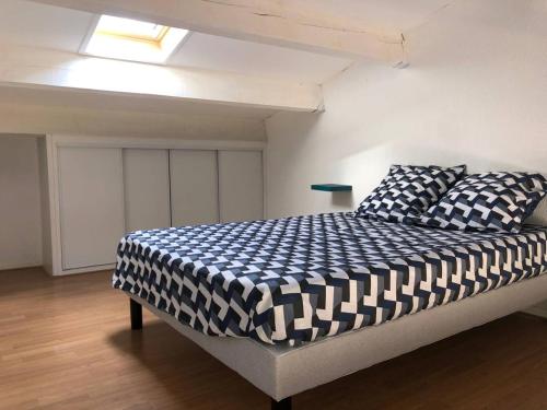 une chambre avec un lit avec une couette noire et blanche dans l'établissement Appartement T2 Mezzanine, 4 pers, proche plage, parking privé - FR-1-81-538, au Barcarès