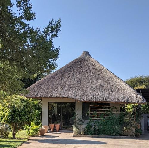 a building with a thatched roof with a window at Sunbirds Chobe Hotel in Kasane