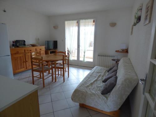 Il dispose d'une cuisine et d'un salon avec un canapé et une table. dans l'établissement Charmant T2 à 2 pas de la plage avec terrasses, parking et local vélo – 5 pers, ménage inclus - FR-1-319-435, à Biscarrosse