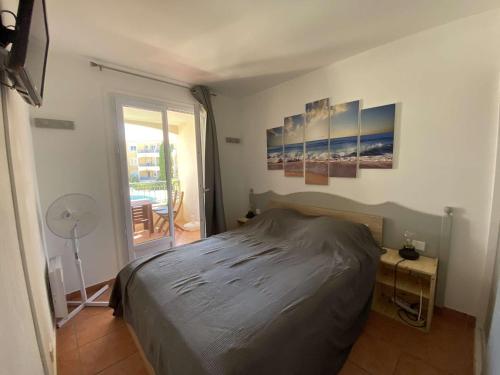 - une chambre avec un lit et une porte donnant sur un balcon dans l'établissement Appartement 2P aux Issambres, piscine, tennis, parking sécurisé - FR-1-226-465, à Roquebrune-sur Argens
