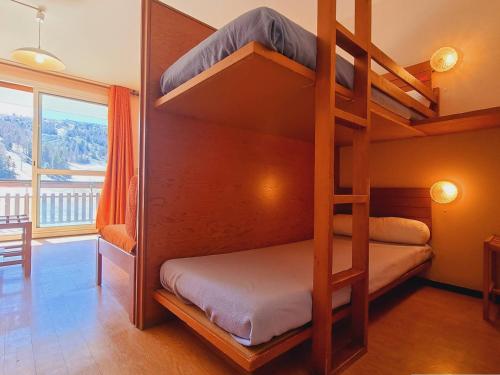 Ce lit superposé se trouve dans un dortoir avec une échelle. dans l'établissement Appartement Le Dévoluy, 1 pièce, 4 personnes - FR-1-525-185, à Saint-Étienne-en-Dévoluy