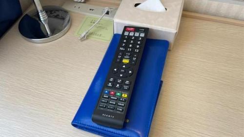 a remote control on a blue stand next to a box at Toyoko Inn Kashiwa-eki Higashi-guchi in Kashiwa