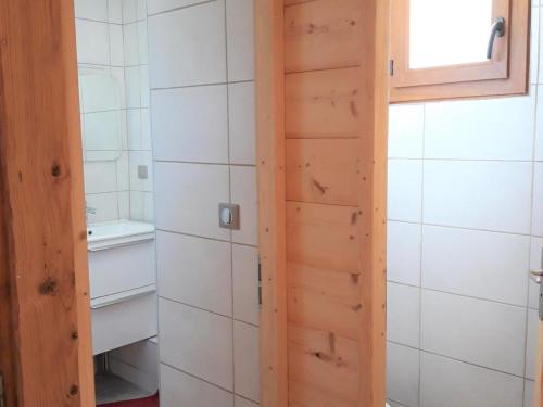 a bathroom with a wooden door and a sink at Appartement Albiez-Montrond, 2 pièces, 5 personnes - FR-1-618-5 in Albiez-Montrond