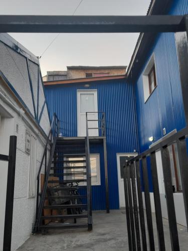 un edificio azul con una escalera que conduce a una puerta en AzulTDF, en Ushuaia