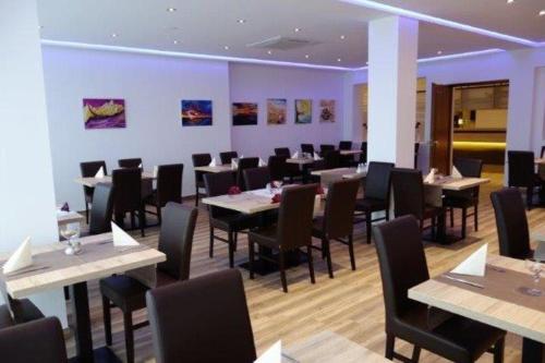 un restaurante con mesas, sillas y paredes púrpuras en Eichenhof Hotel GbR en Eislingen