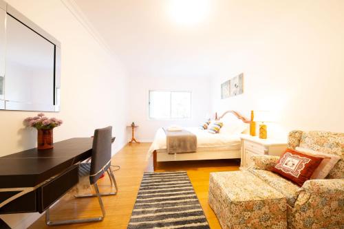 a living room with a bed and a couch at The roses house - Cozy and Modern house in Katoomba in Katoomba