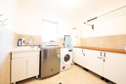 a kitchen with a washing machine and a sink at The roses house - Cozy and Modern house in Katoomba in Katoomba